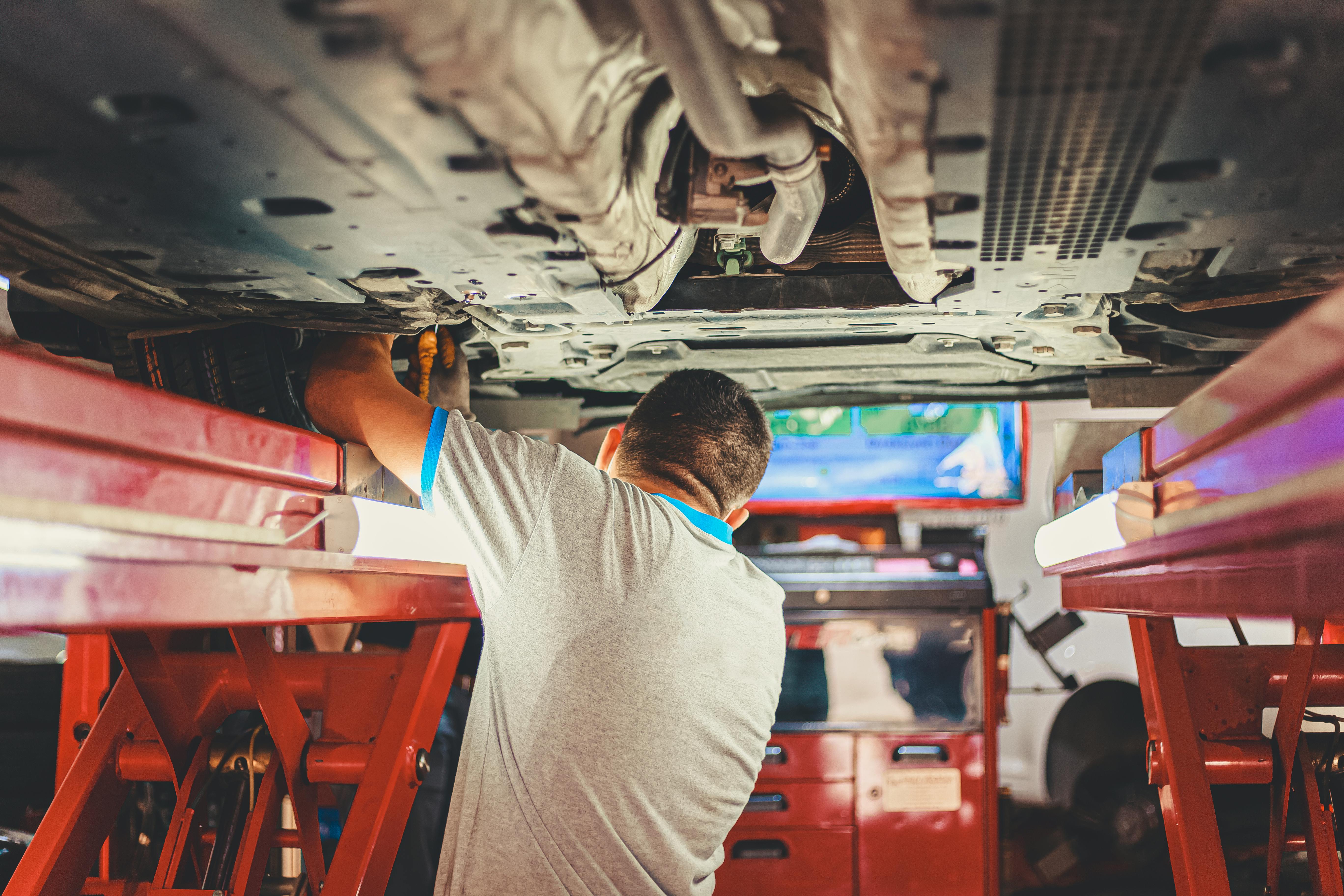 Northern Ireland MOT check - mechanic inspecting vehicle underside at DVA centre