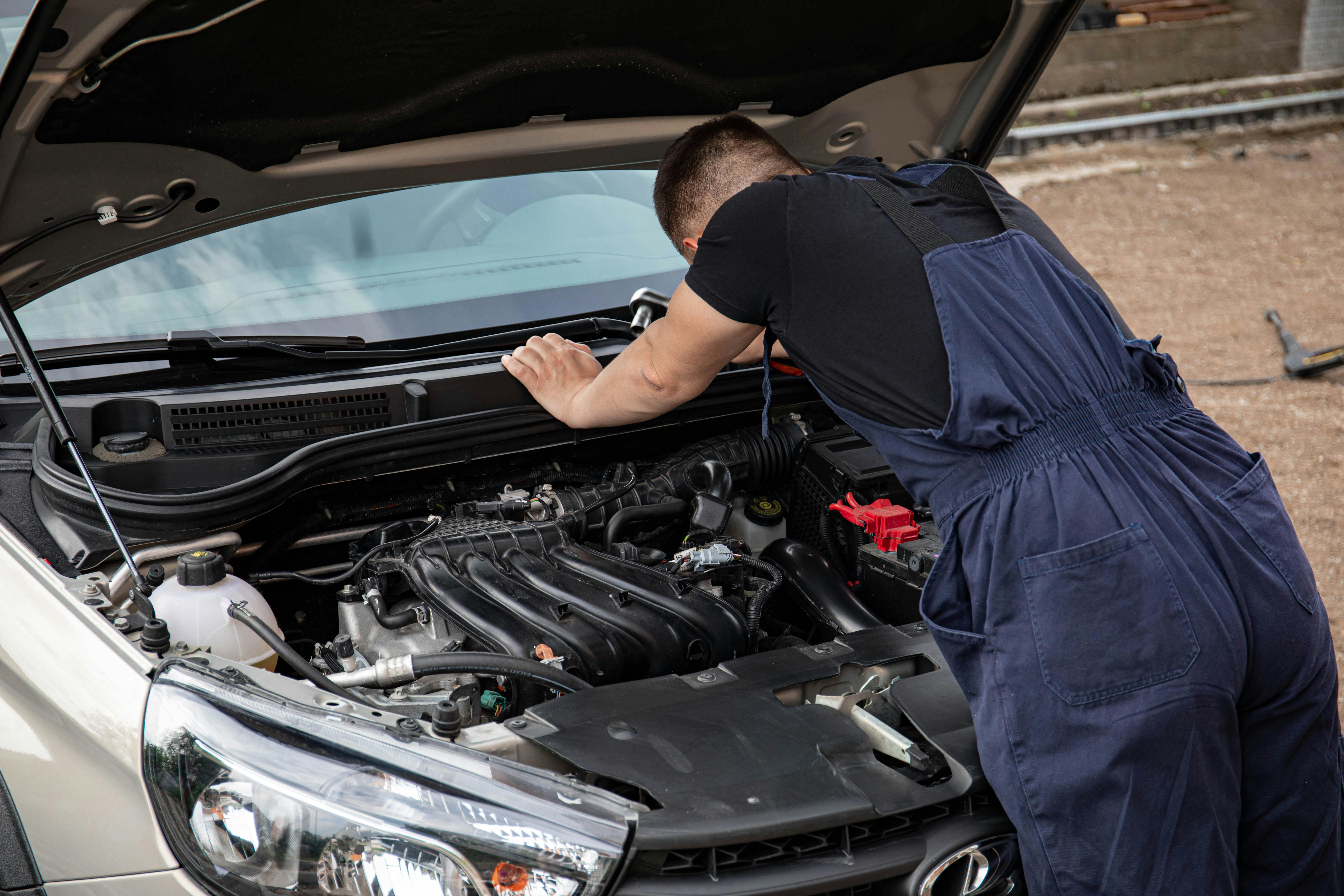 MOT advisory check - mechanic inspecting engine at UK test centre