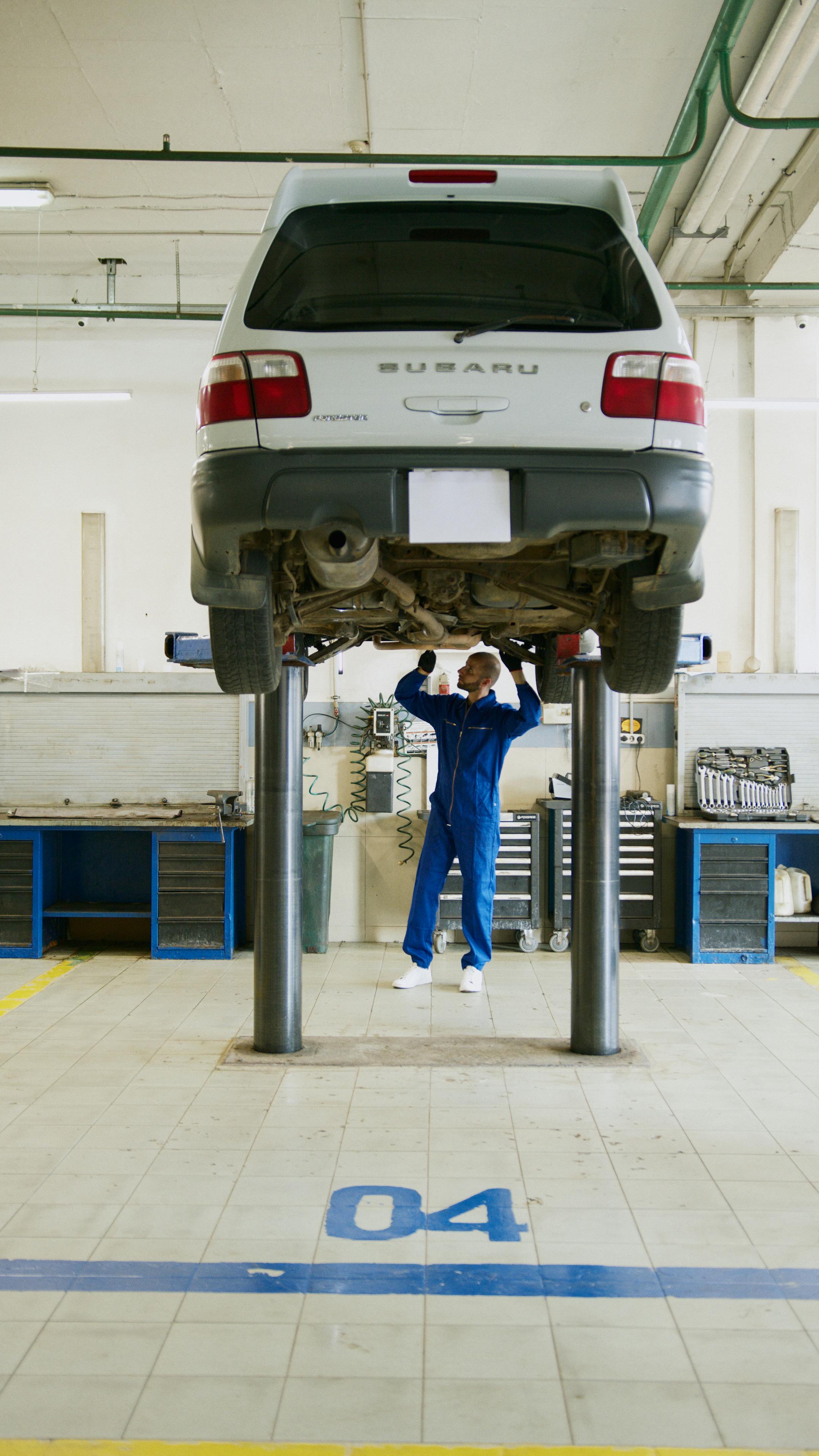 MOT test inspection — mechanic checking car underside in UK garage